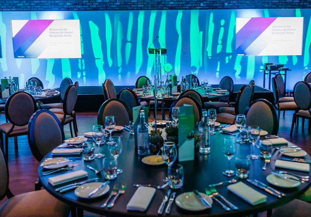 A round dinner table, with a presentation in the background