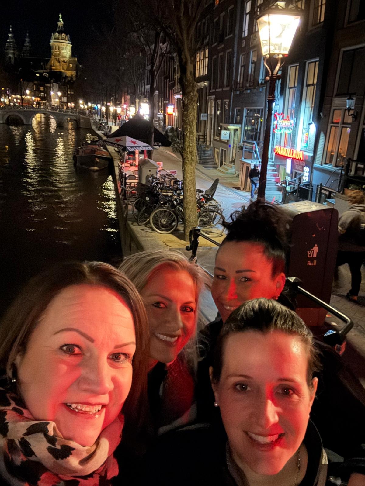 Four team members in a city, with a river and buildings in the background