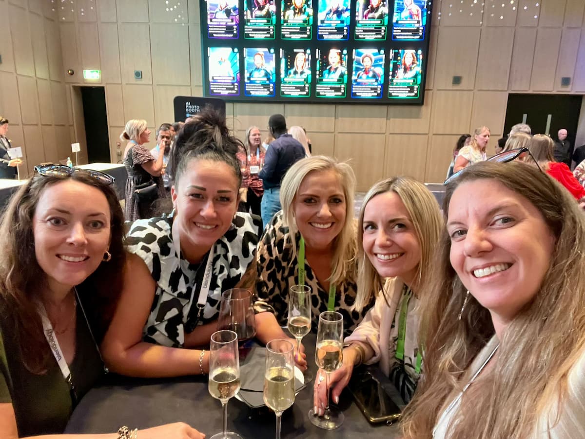 A group of 5 team members sat around a table with drinks